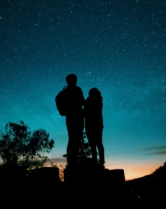 Pareja mirando juntos el cielo y observando las estrellas.
